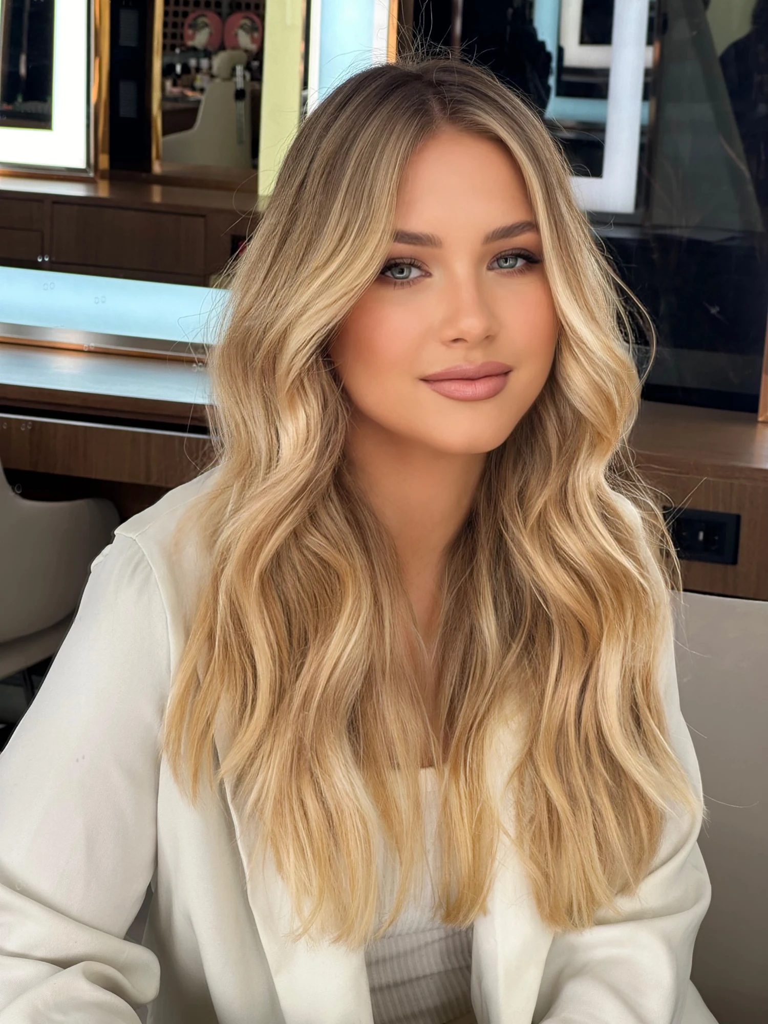 Cabelo loiro neutro com ondas longas e acabamento suave